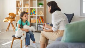 BCBA guiando sesión de terapia ABA con niño