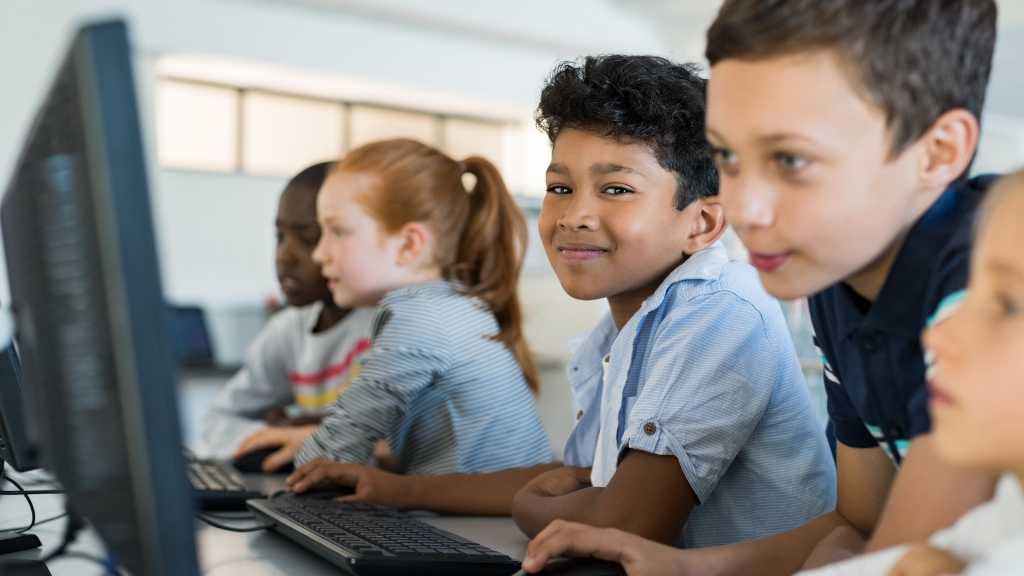 Niños en clase de informática mostrando integración escolar, útil para ilustrar consejos prácticos para apoyar la adaptación de niños con autismo.