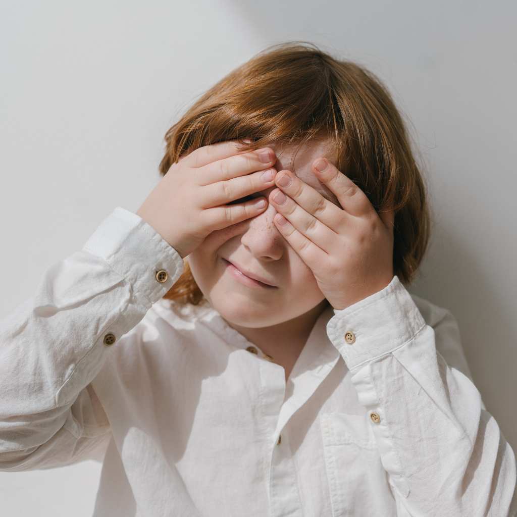 Niño con autismo cubriéndose los ojos