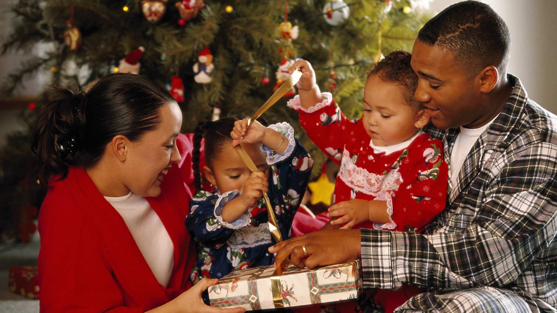 Familia compartiendo regalos durante las celebraciones, reflejando cómo las festividades pueden sentirse distintas para el autismo y las festividades