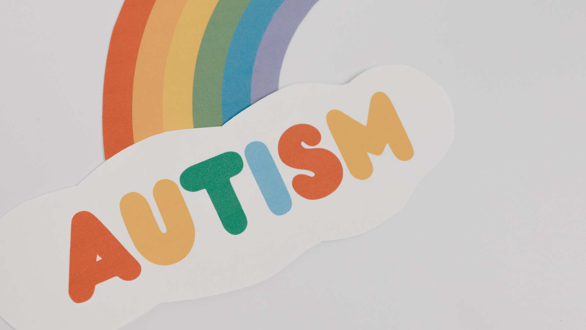 Ilustración de un arcoíris con la palabra “AUTISM” en colores brillantes, usada para acompañar contenido relacionado con preguntas sobre ABA