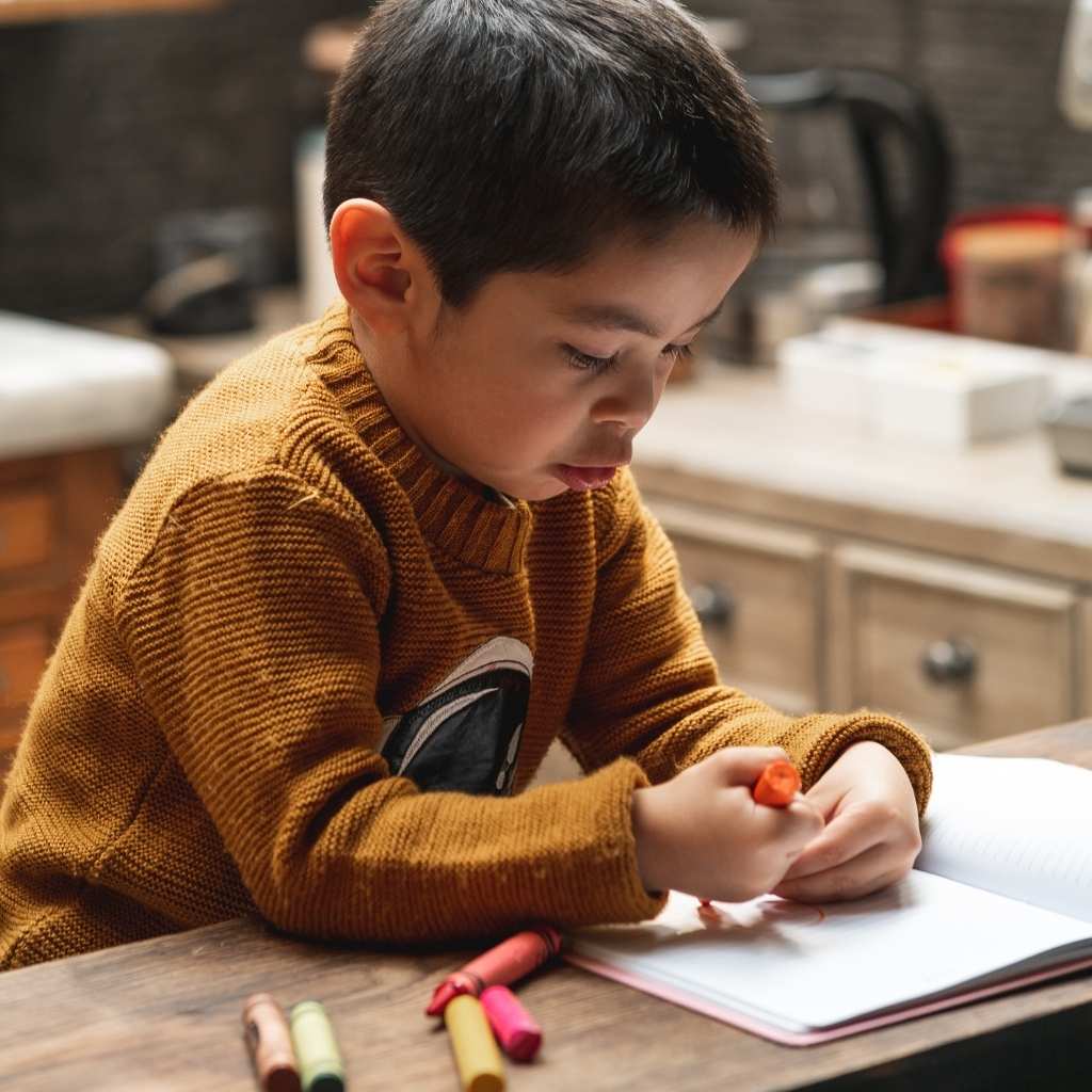 Niño escribiendo en una libreta en casa, relacionado con preguntas sobre ABA