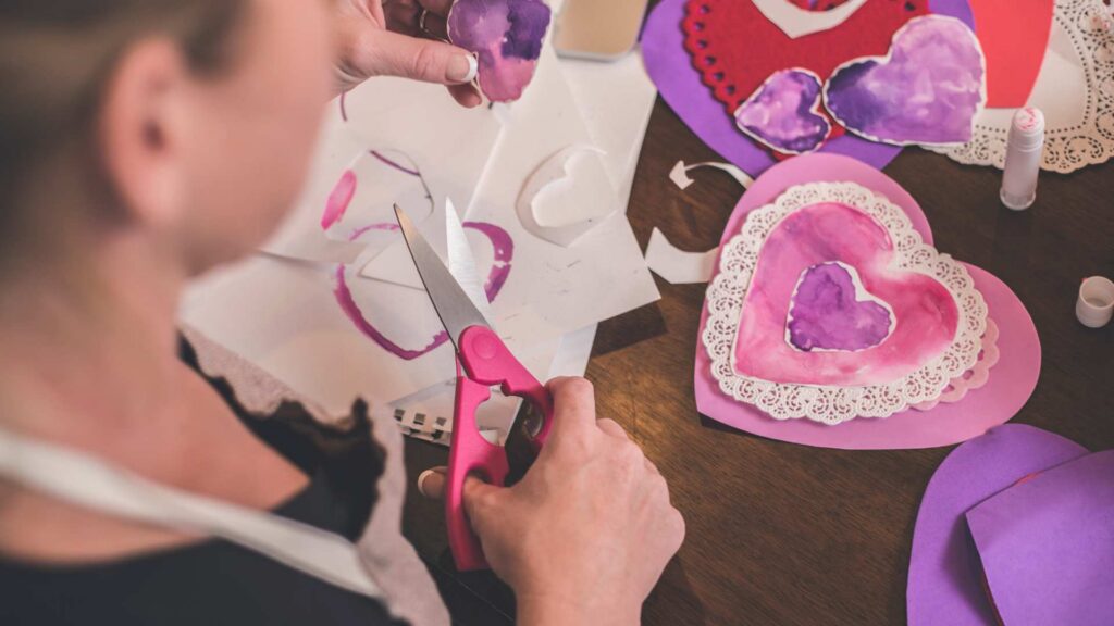 Niña realizando manualidades sensorialmente amigables con el Día de San Valentín y el autismo.