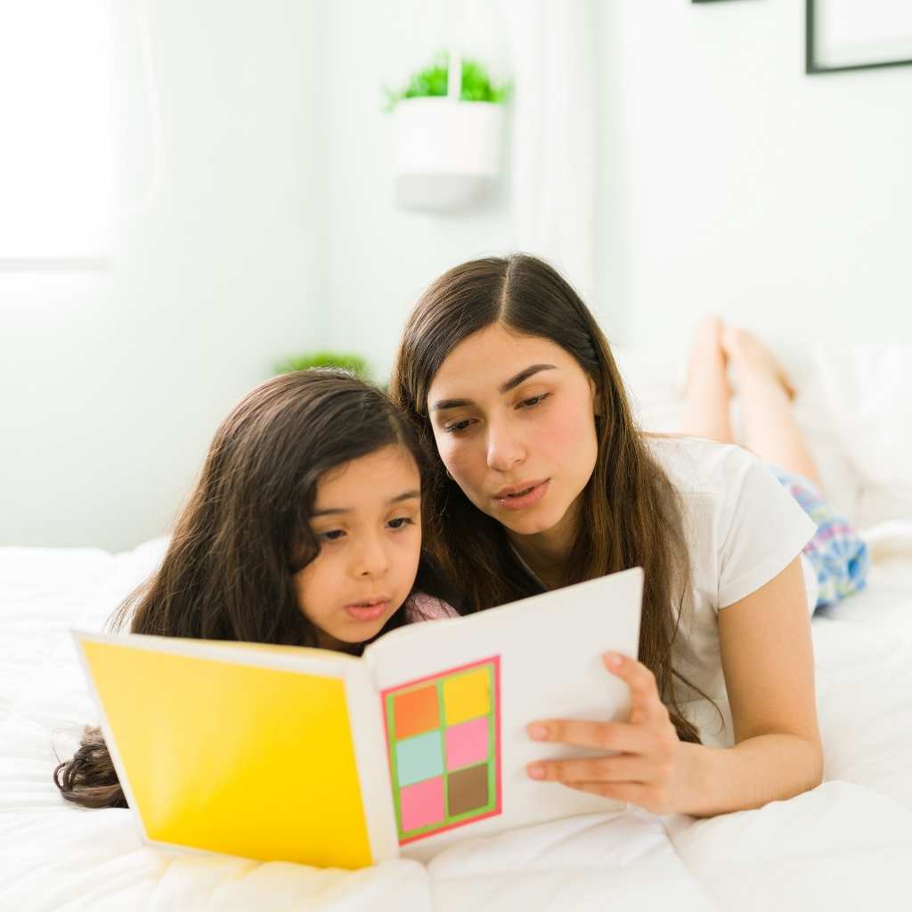 Niña y adulta leyendo un cuento representando una actividad que puede realizarse en San Valentín con niños con autismo