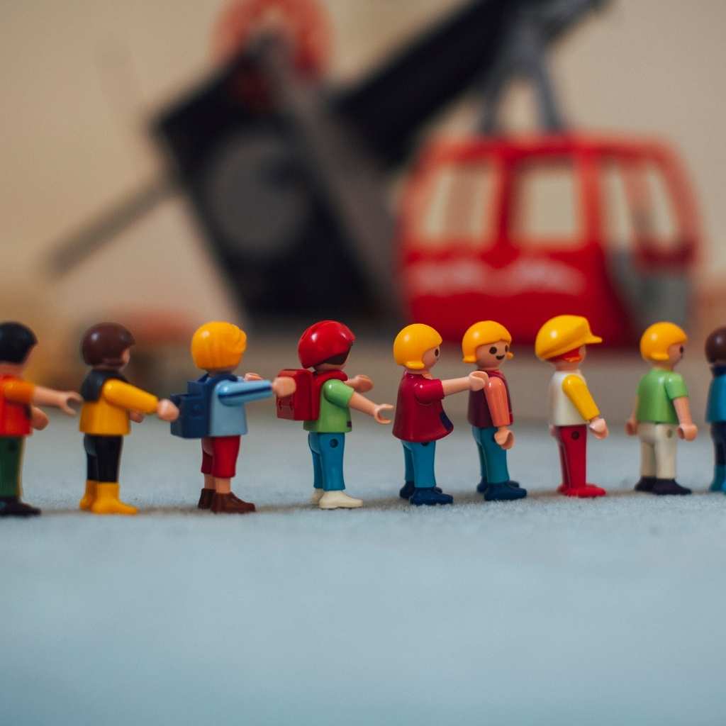 Muñecos de juguete colocados en una línea recta, representando un comportamiento repetitivo en niños pequeños