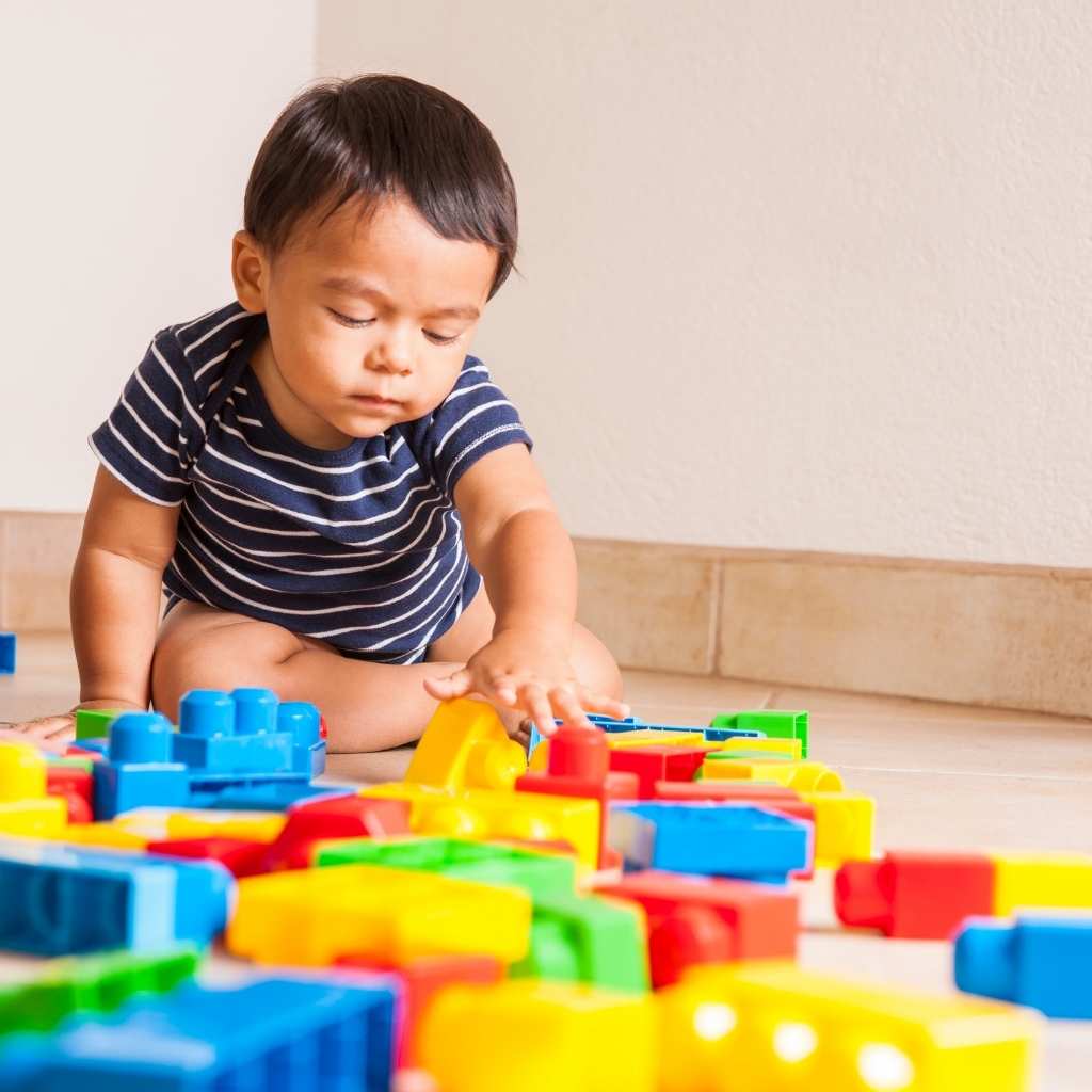Niño pequeño jugando con bloques durante evaluación de autismo