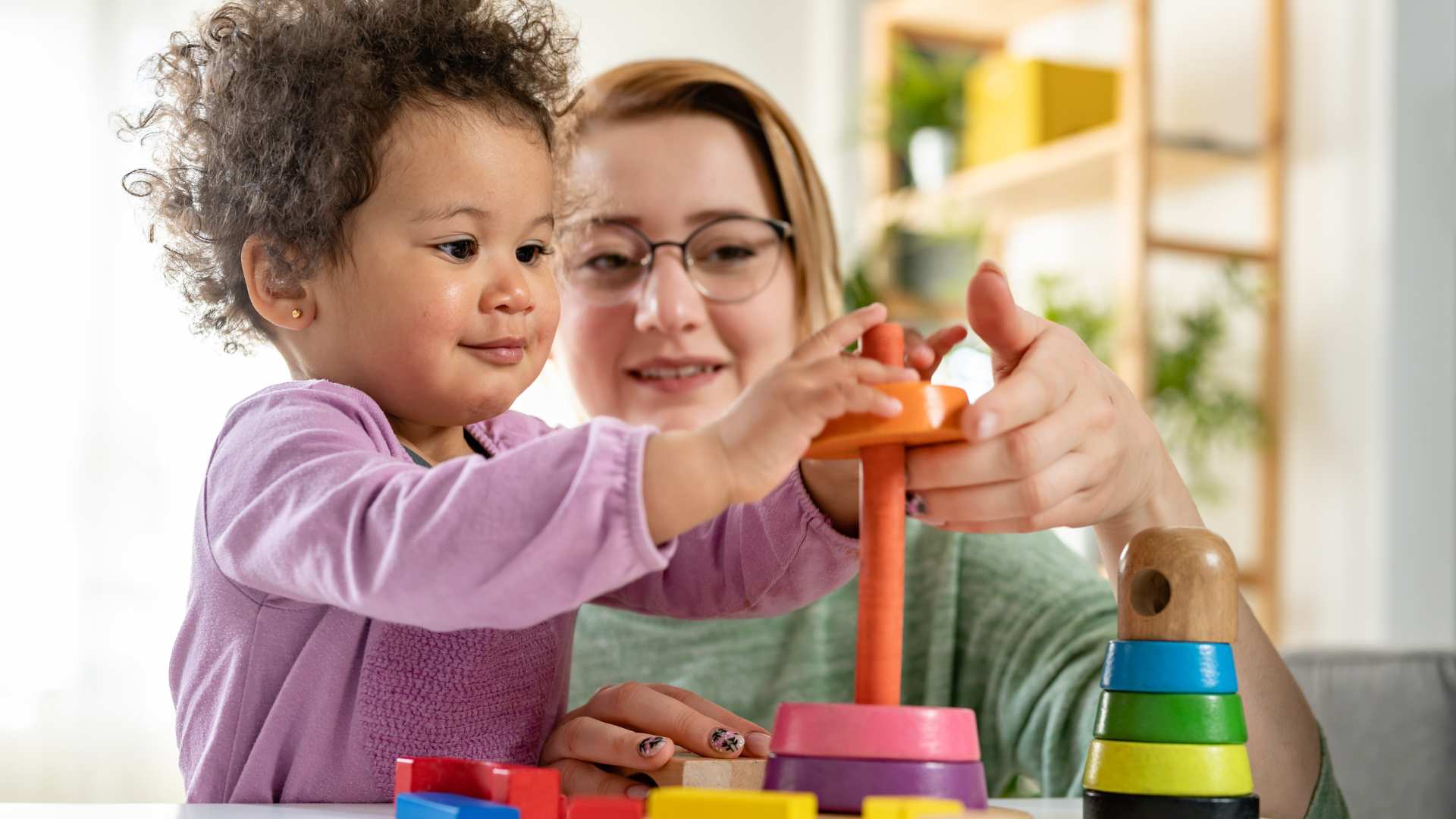 Cuidadora y niña realizando una actividad de juego guiada al iniciar la terapia ABA para niños pequeños