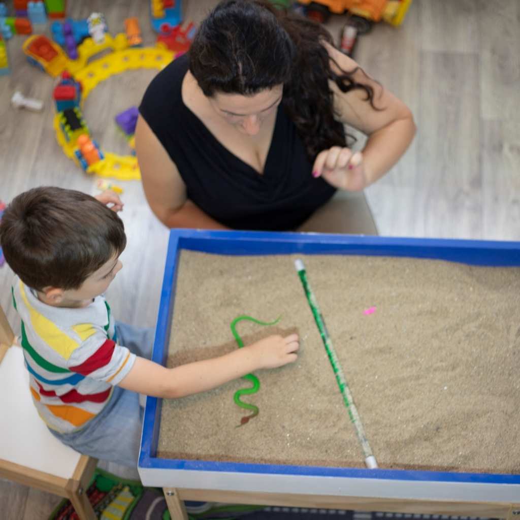 Niño participando en una actividad de juego sensorial durante una sesión de terapia ABA