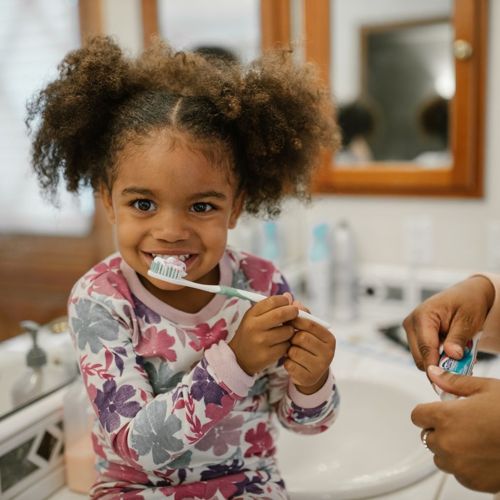 Niña practicando una actividad de aprendizaje con apoyo de un adulto en casa