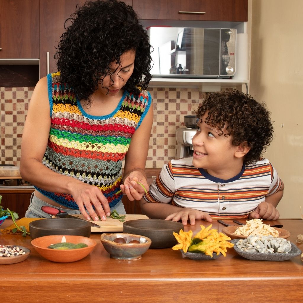 Madre e hijo preparando alimentos juntos en la cocina